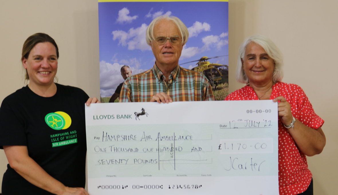 Three people holding a large cheque for £1,700