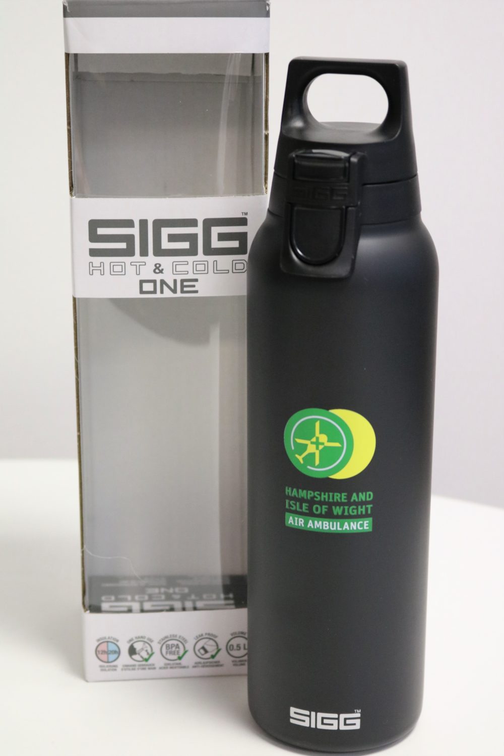 Black SIGG bottle featuring the green and yellow charity logo