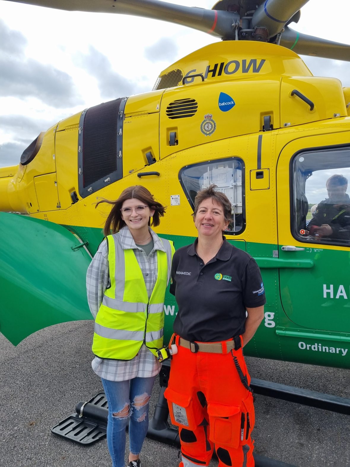 Two people stood in front of a helicopter