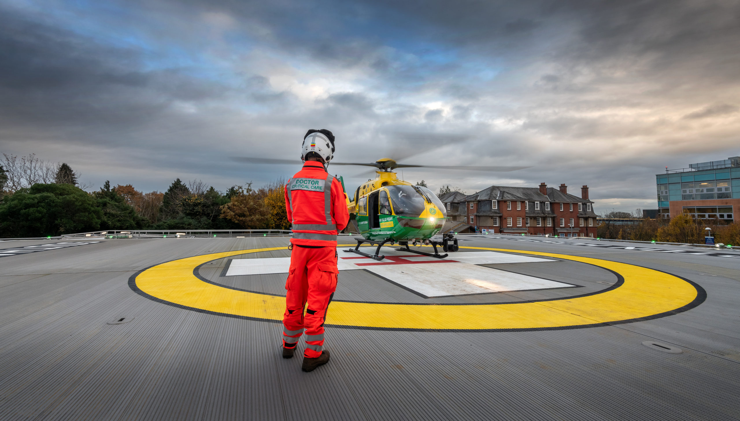 Doctor Simon in front of helicopter on helipad