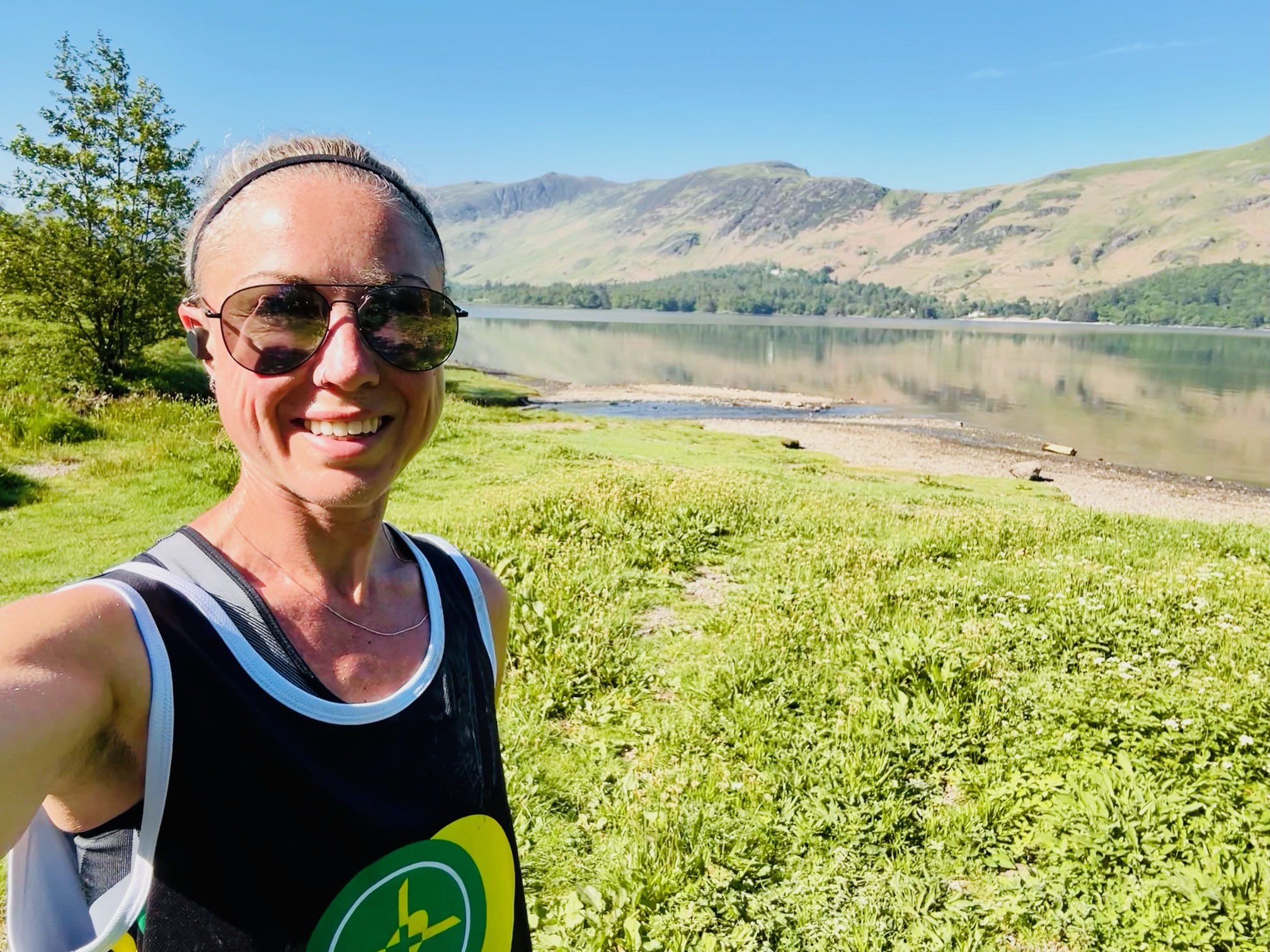 Specialist Paramedic Dolly McPherson smiling at the camera with hills and a lake behind her