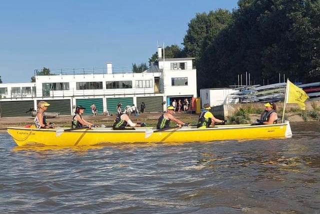 A team of rowers in a boat on the River Thames.