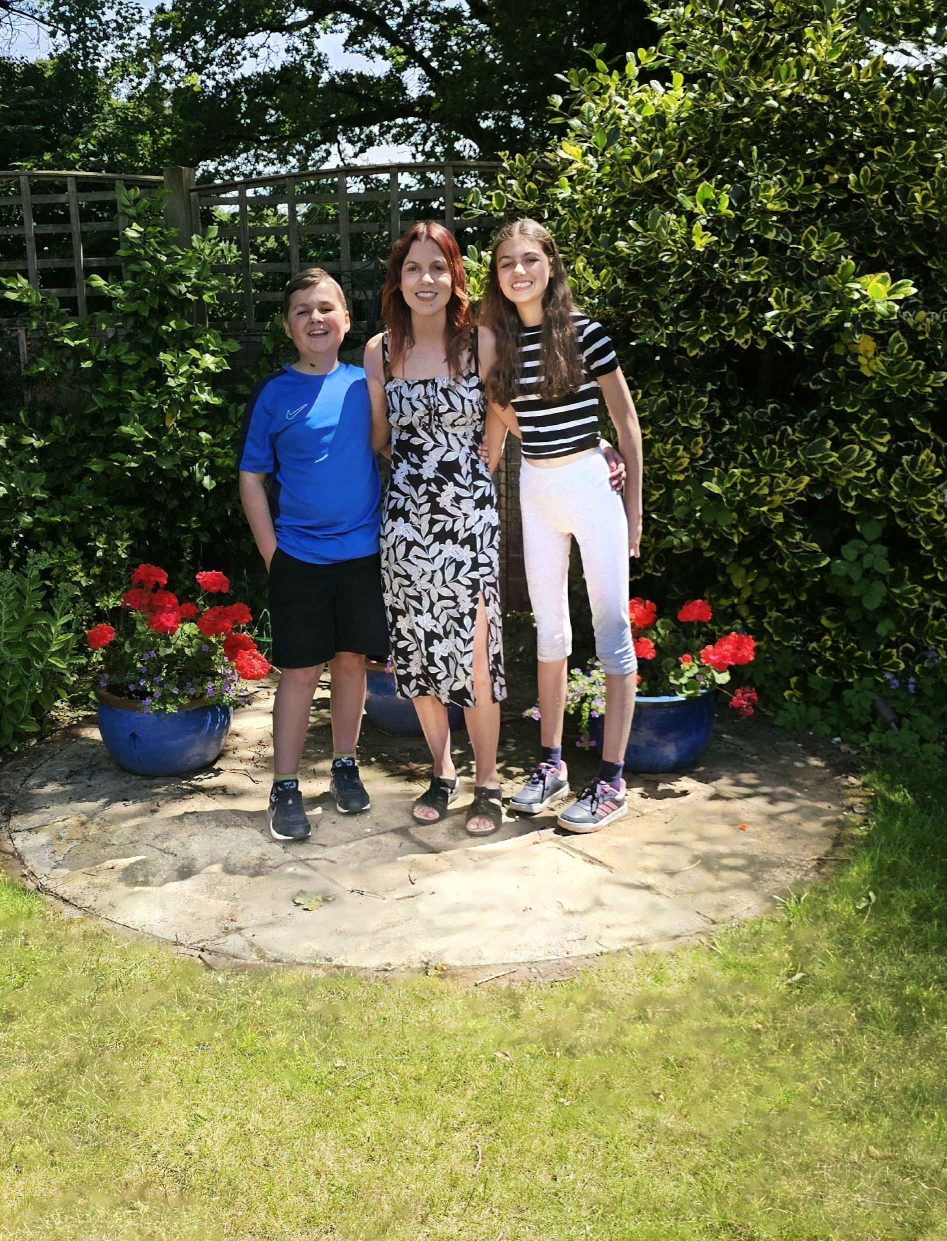 Lianne stood in a sunny garden with her two children