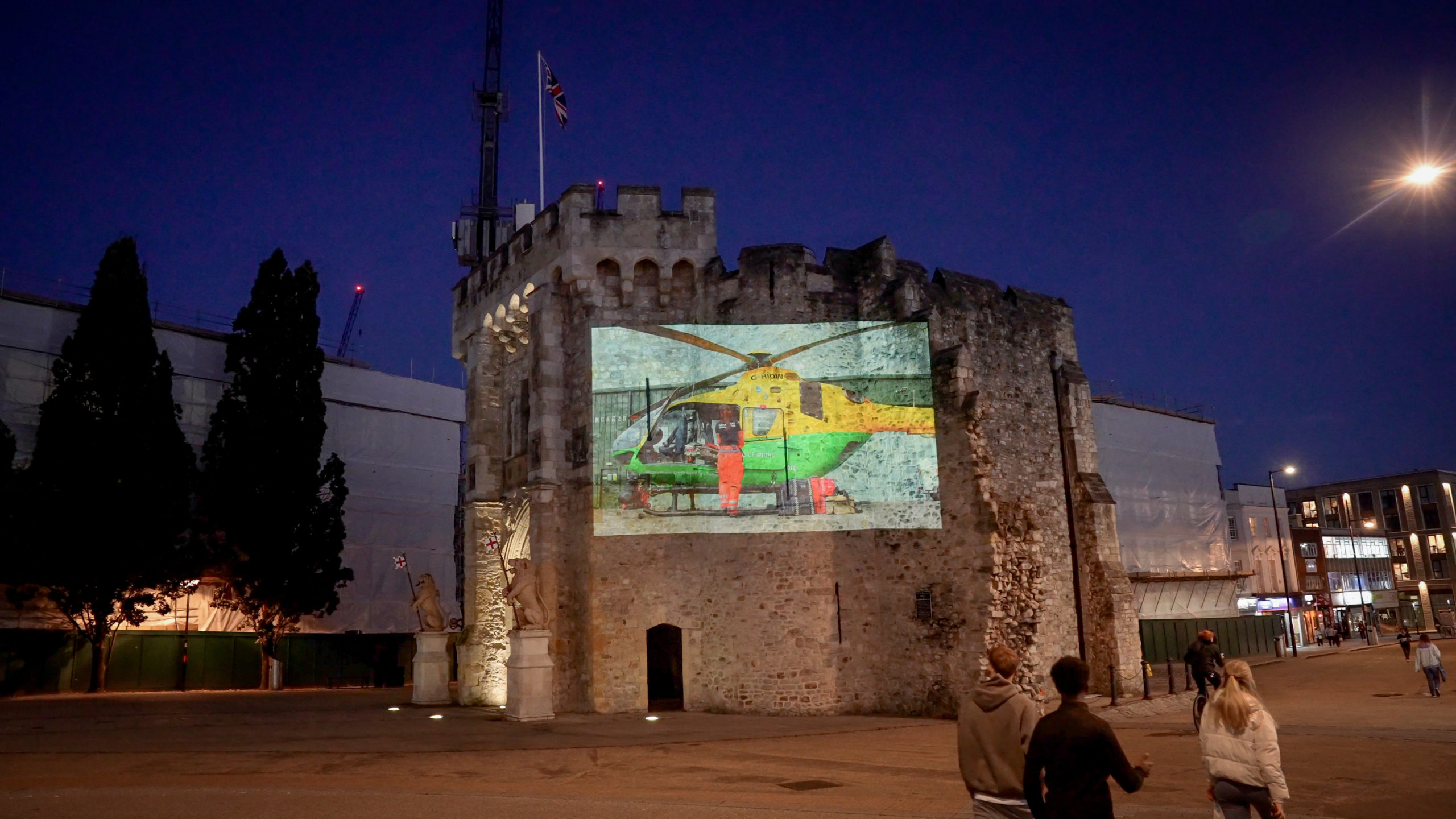 A projection showing a helicopter being displayed on a historical building in a city centre.