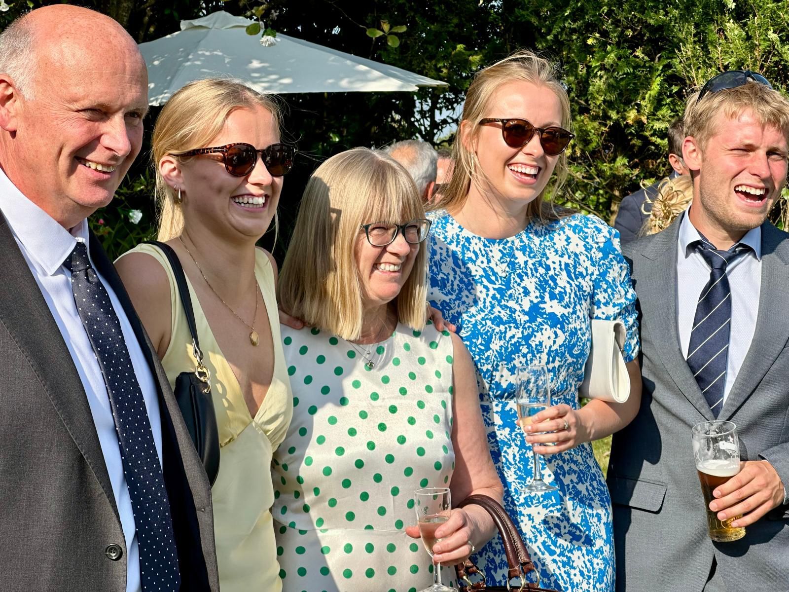 A group of people at wedding-like event smiling and laughing.