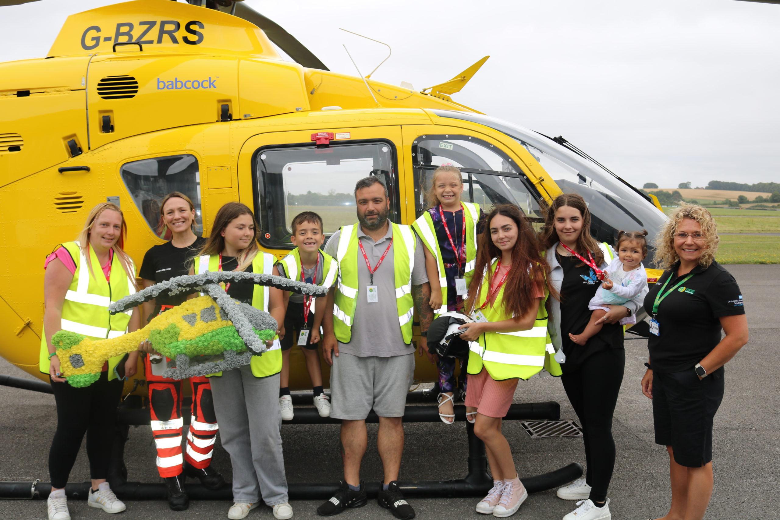 A family standing in front of a helicopter.