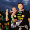 Dash in the Dark participants holding their medals after the run.