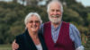 A man and a woman stood side by side smiling at the camera.