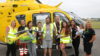 A family standing in front of a helicopter.