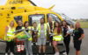 A family standing in front of a helicopter.